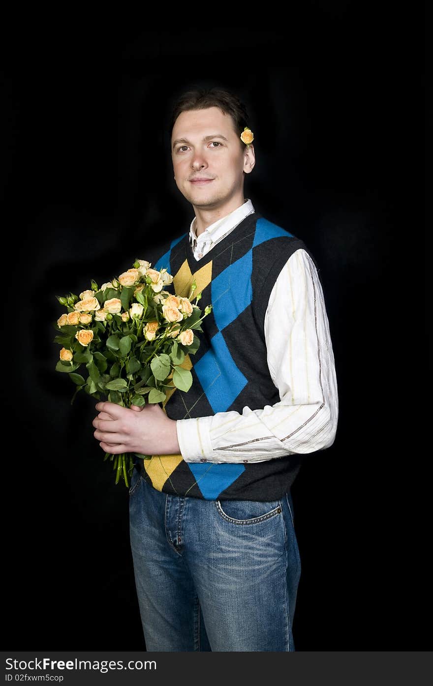 A young, attractive and happy man with flowers