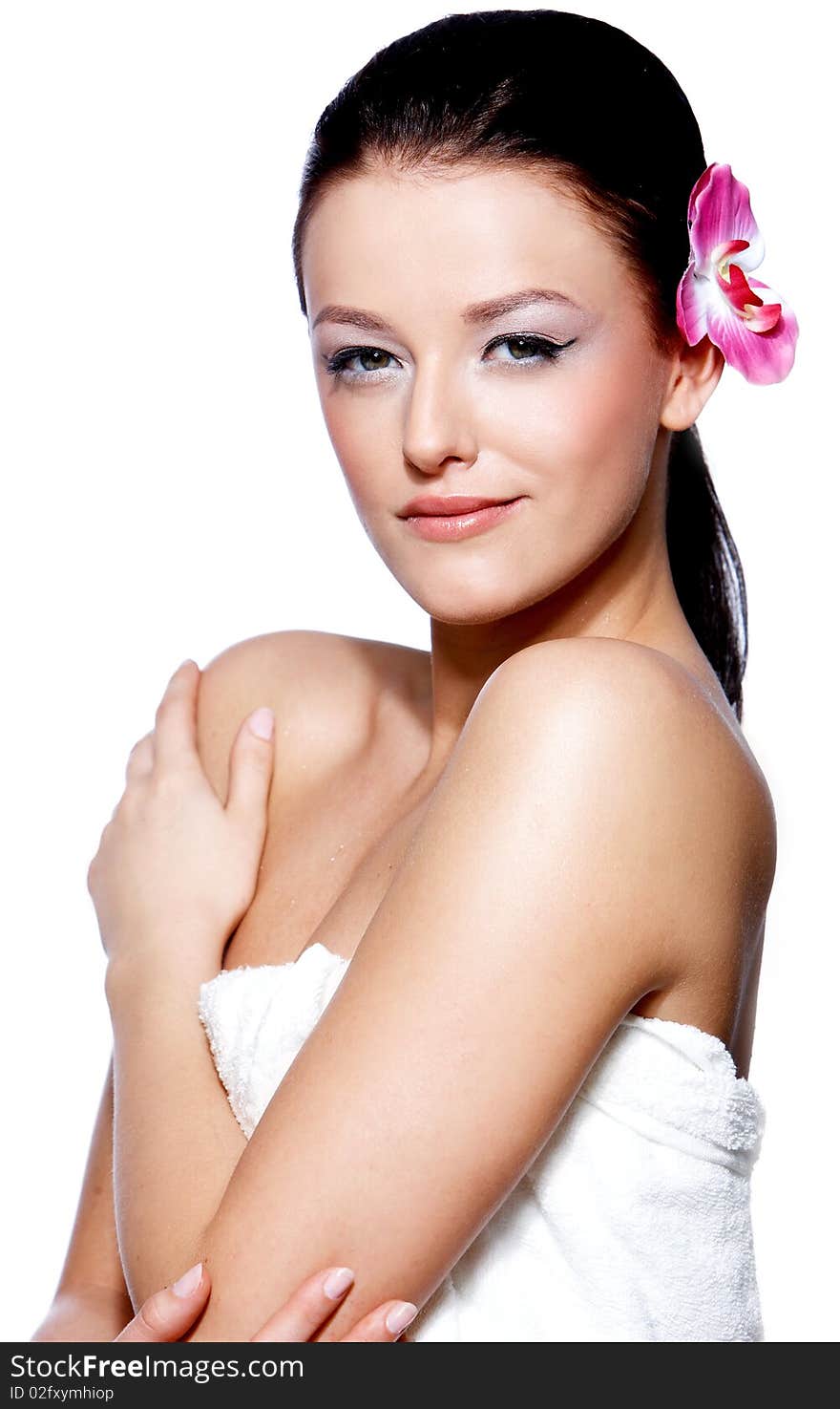 Portrait of a beautiful brunette woman with a pink orchid