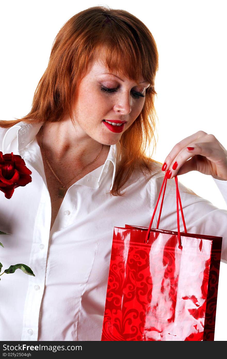 Beautiful redhead girl with a gift and a rose