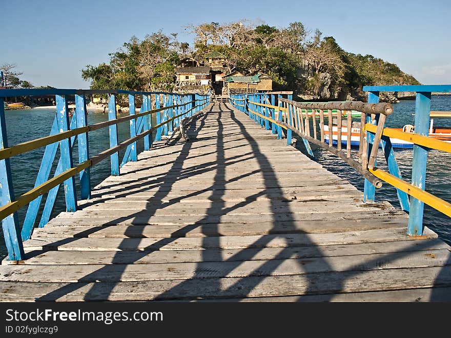 A wooden bridge connects two small islands which are part of the Hundred Islands in the Philippines. A wooden bridge connects two small islands which are part of the Hundred Islands in the Philippines.