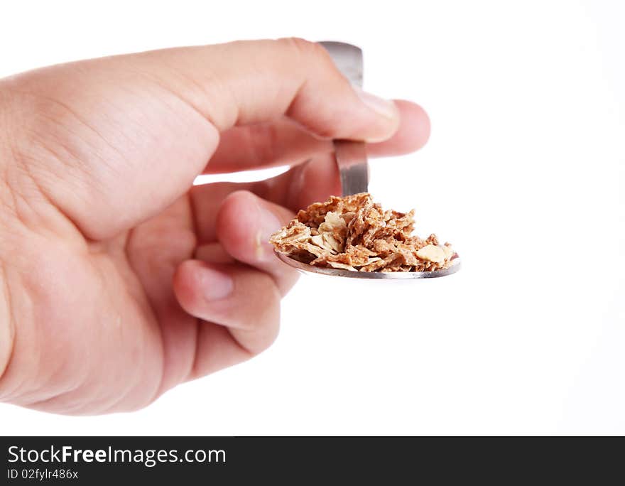 Hand with Cereal on a spoon over white background. Front view