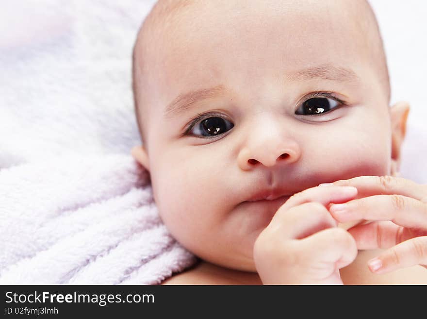 Beauty baby looking at camera on white blanket