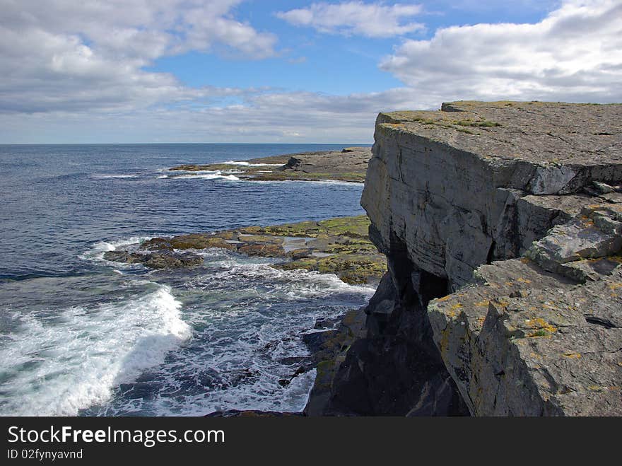 A rocky coastline is washed by the waves