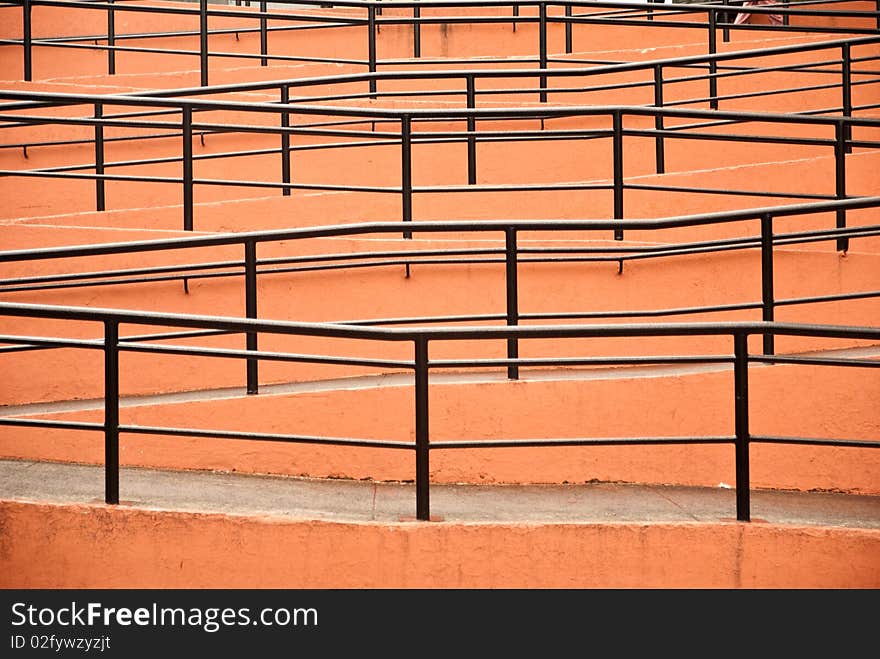 A serpentine footpath ramp with railings forms an unusual pattern with no people. A serpentine footpath ramp with railings forms an unusual pattern with no people