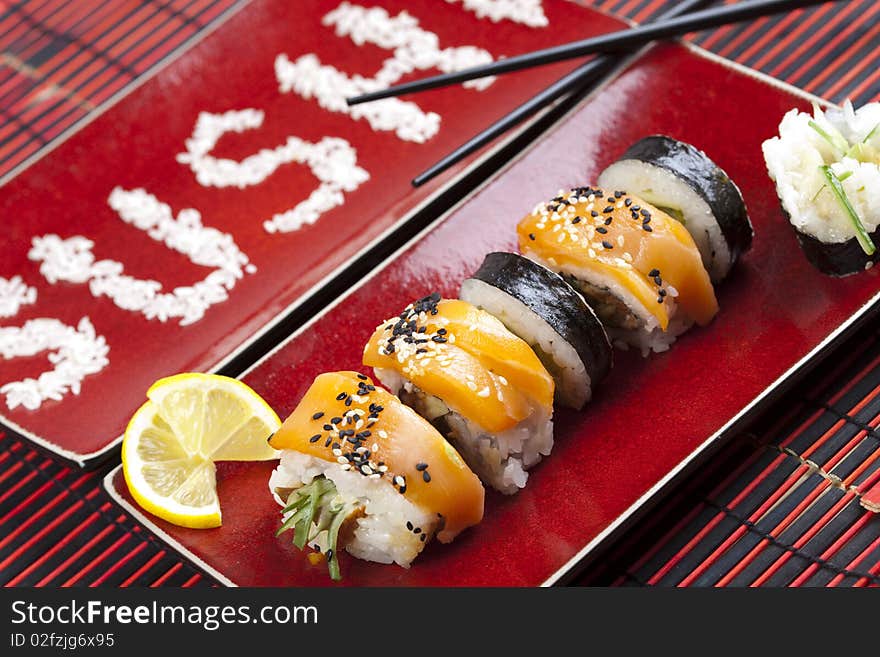 A complete sushi meal with chopsticks on red tatami mat. A complete sushi meal with chopsticks on red tatami mat