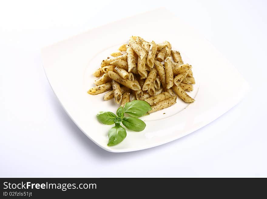 Penne with pesto decorated with basil on a plate