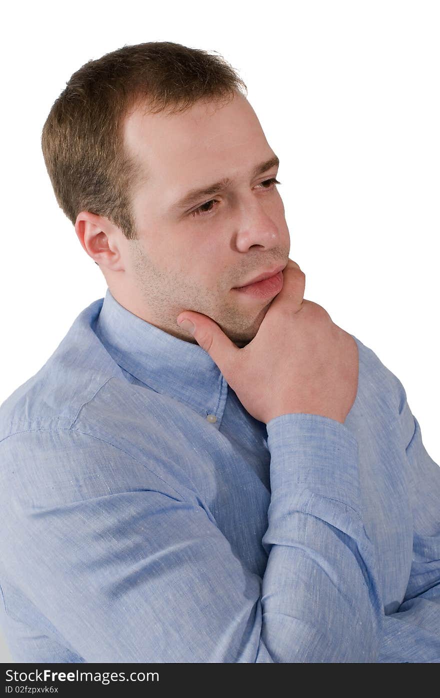 The man in a blue shirt thoughtfully rubs a chin, is isolated on a white background