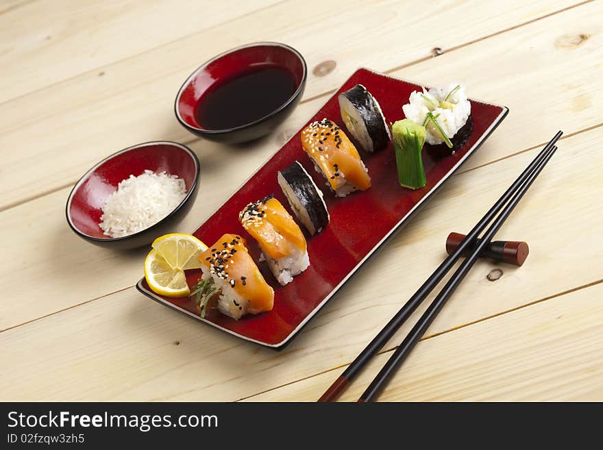 A complete sushi meal with chopsticks on wood