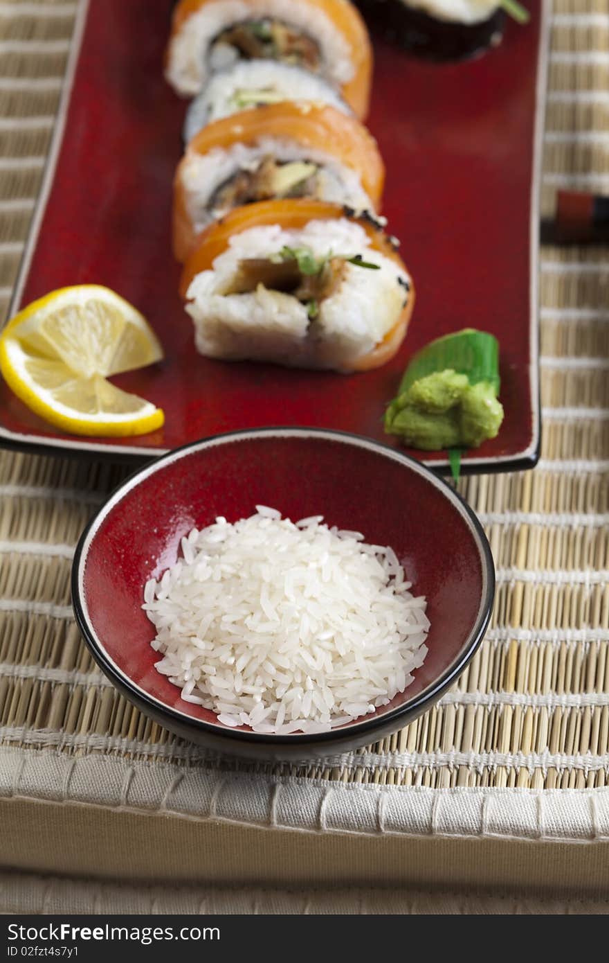 Tuna roll on square green plate with wasabi and ginger. Soy dipping bowl in background. Shot with very shallow depth of field. Tuna roll on square green plate with wasabi and ginger. Soy dipping bowl in background. Shot with very shallow depth of field.