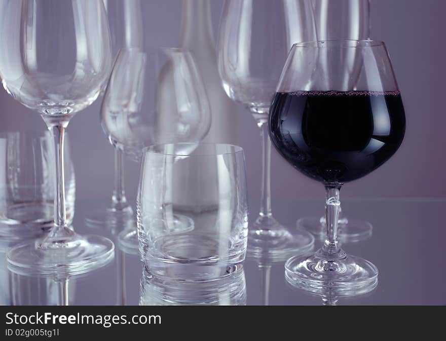 Red wine and wineglasses on a mirror table