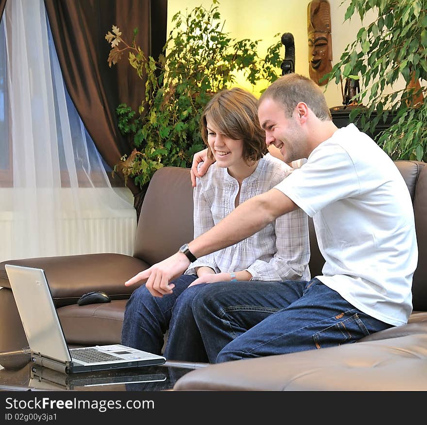 Brother and sister in front in computer in a sofa