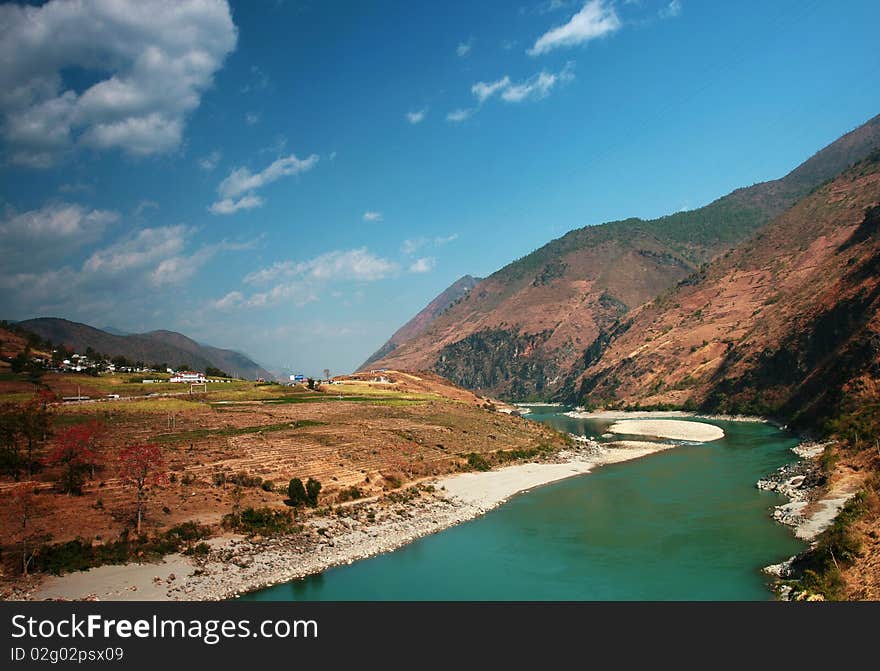 The Nu River Grand Canyon, in Yunnan, China. It's taken in Spring, the river is green and beautiful, surrounded by mountains are high, people living in the quiet of this beautiful land.