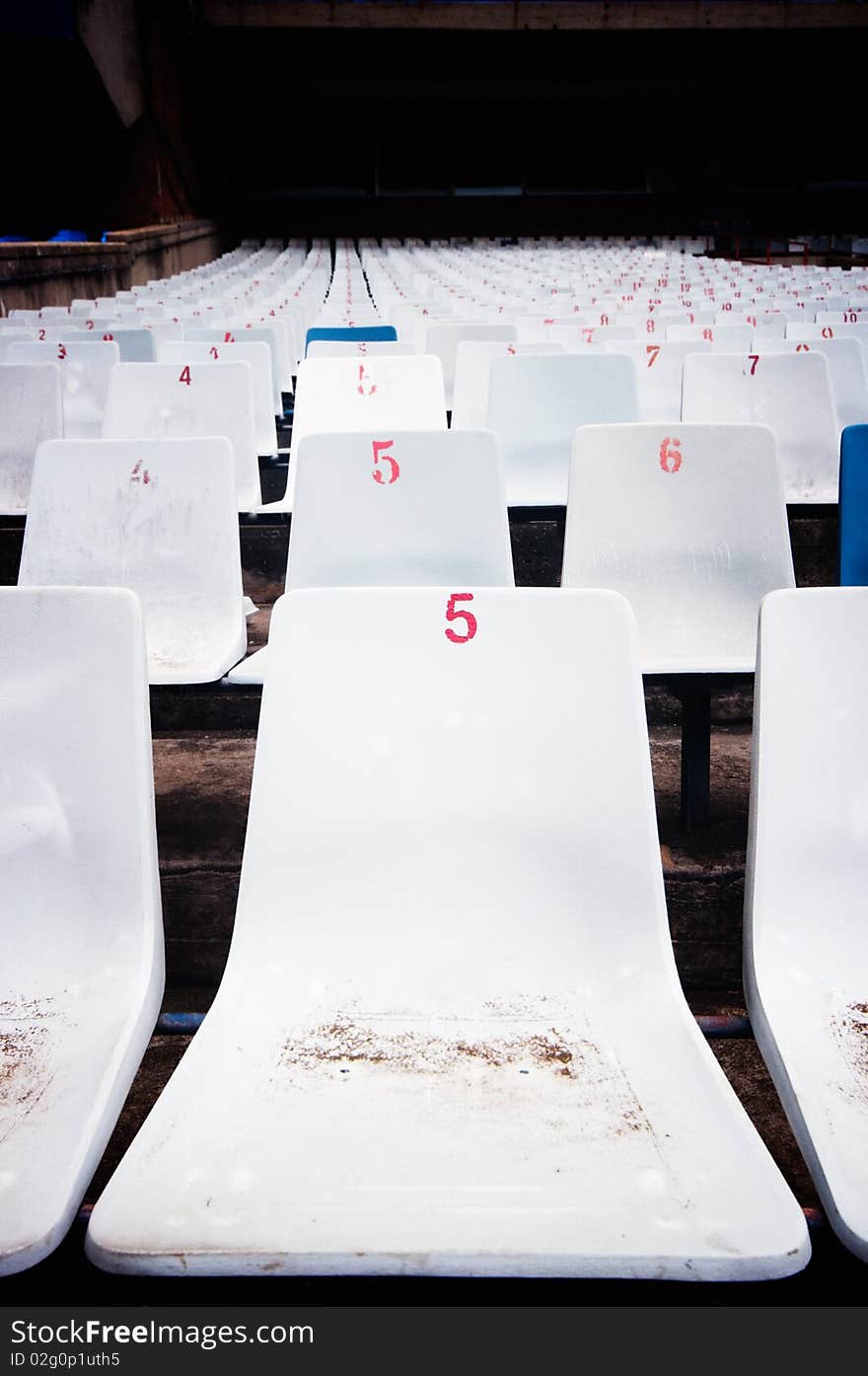 Close up of a row of seats in the stadium of pretoria host of world cup 2010 soccer matches. Dust cover the seats under renovation. cross processing technique used to improve the mood. Close up of a row of seats in the stadium of pretoria host of world cup 2010 soccer matches. Dust cover the seats under renovation. cross processing technique used to improve the mood.