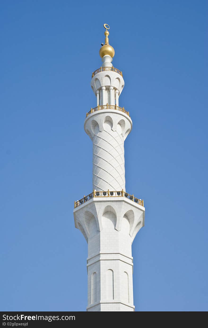 The intricately designed marble clad minaret with gold cresent and balustrade designs