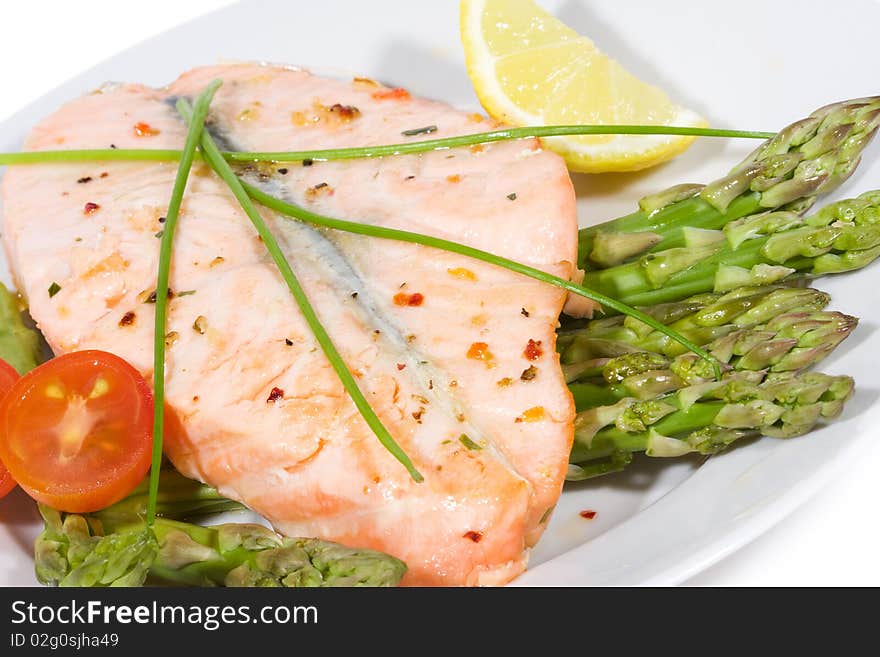 Grilled salmon with vegetables as background