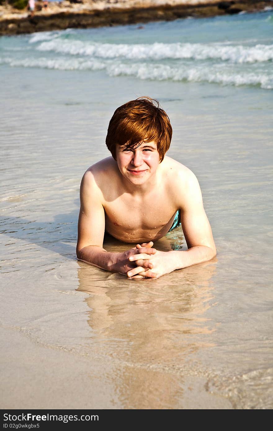 Happy boy in foam of beach