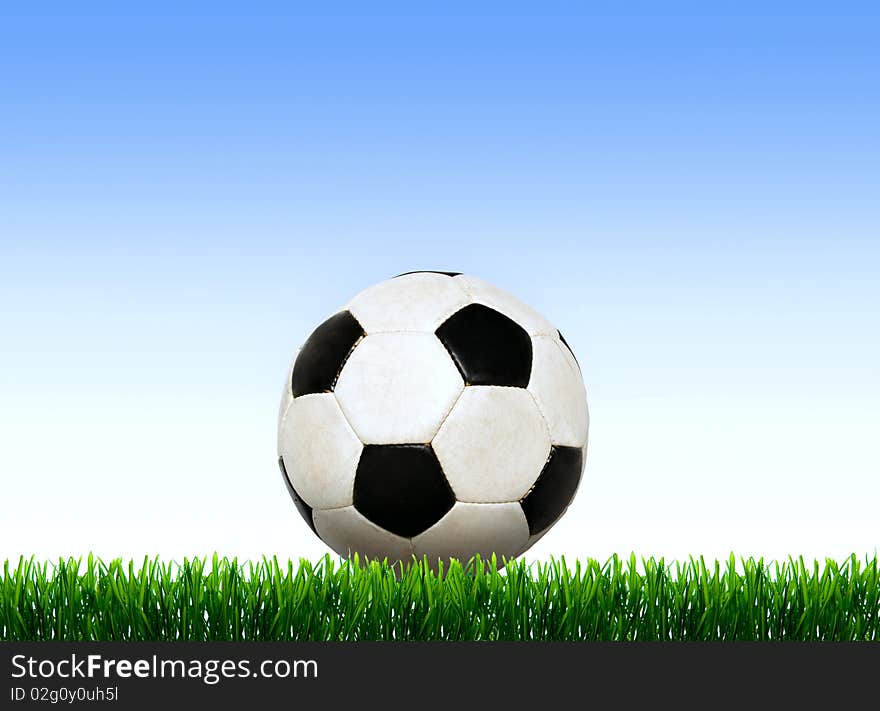 Soccer ball on the green field with grass