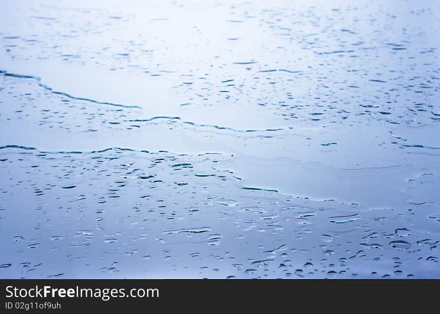 Wet glass surface covered with raindrops. Natural background.