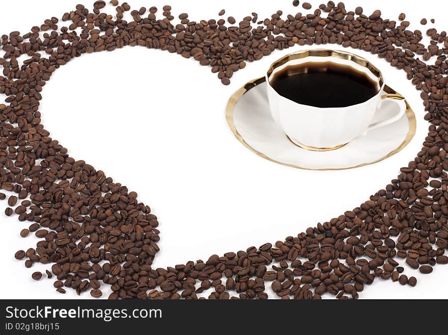 Flavored coffee in the cup and the heart of the coffee beans