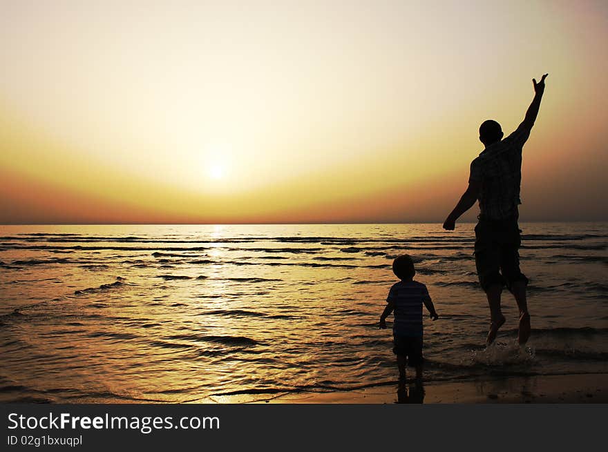 Father and son at sunset on the sea