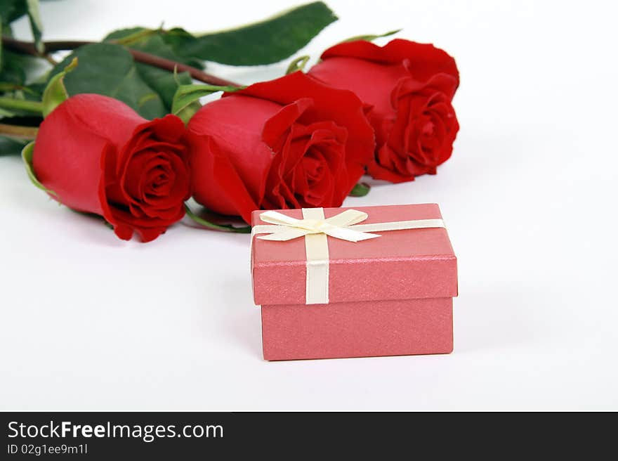 Red roses and gift on white