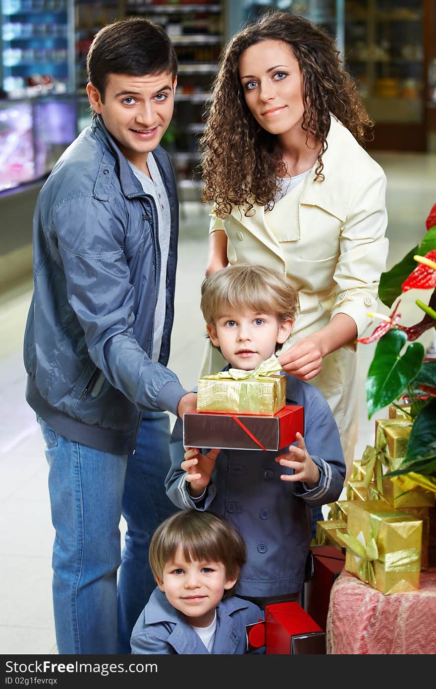 Happy family in shop with boxes of gifts. Happy family in shop with boxes of gifts