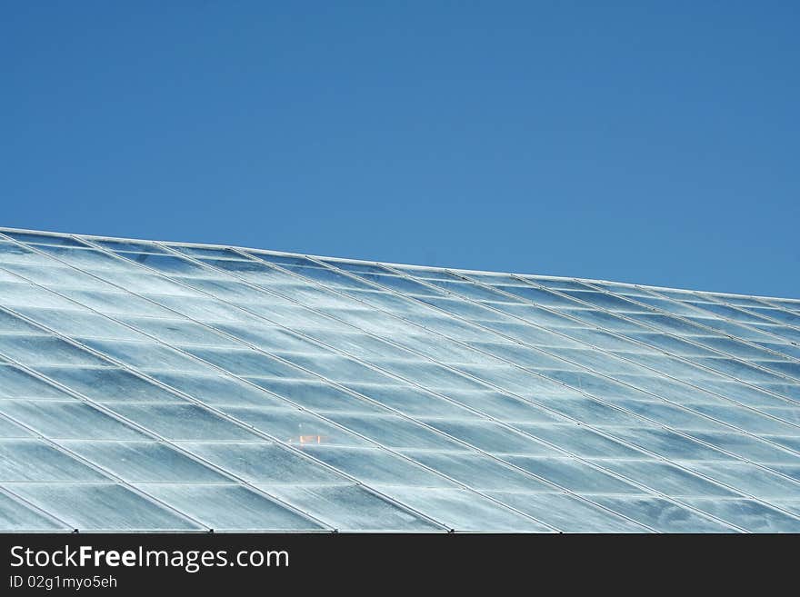 A green house roof with blue sky. A green house roof with blue sky