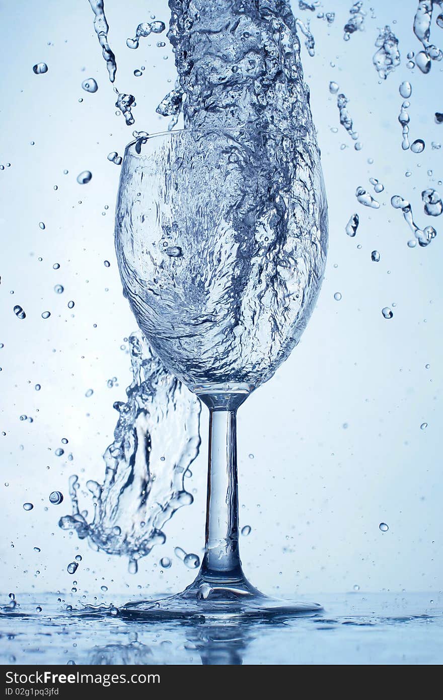 Water is poured into a glass isolated white