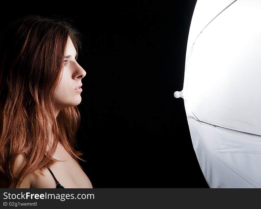 Young female model in front of a lightning umbrella. Young female model in front of a lightning umbrella.