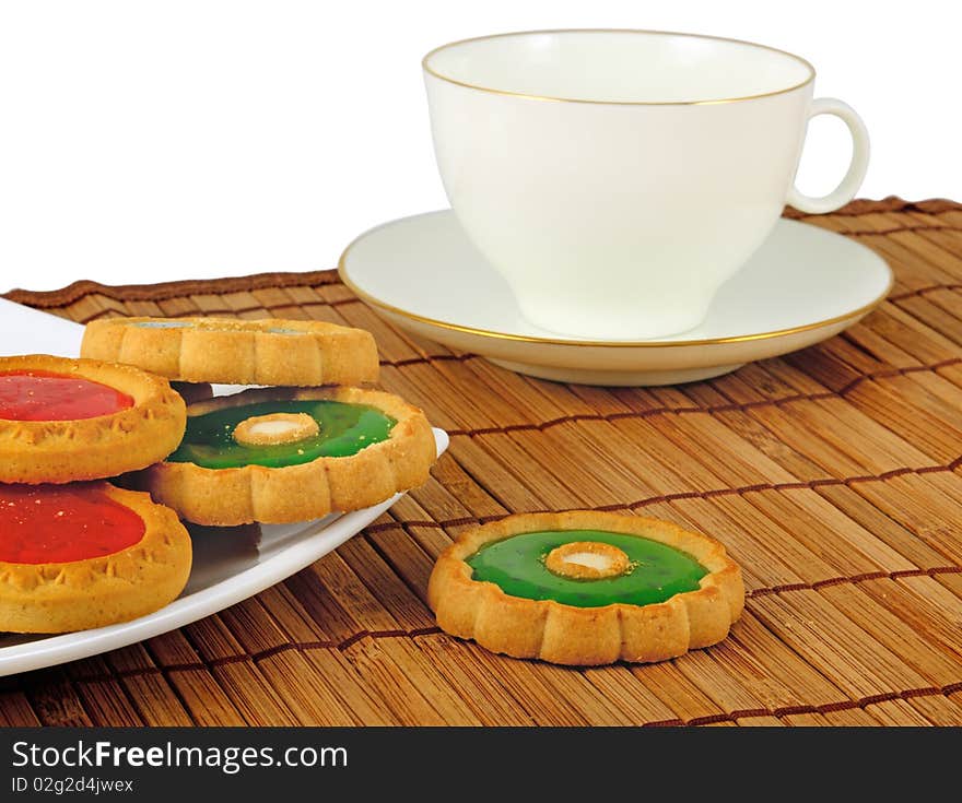 Pastry on plate and white cup with saucer in background. Focus on front of pastry. Pastry on plate and white cup with saucer in background. Focus on front of pastry.