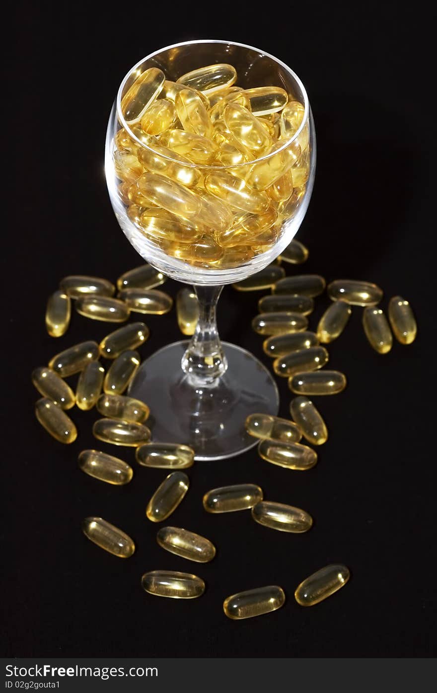 Glass full of nutritional supplement pills on black background. Glass full of nutritional supplement pills on black background.