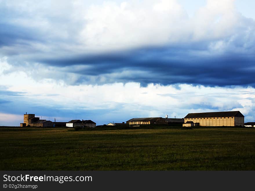 Agricultural farm in the field under clouds. Agricultural farm in the field under clouds