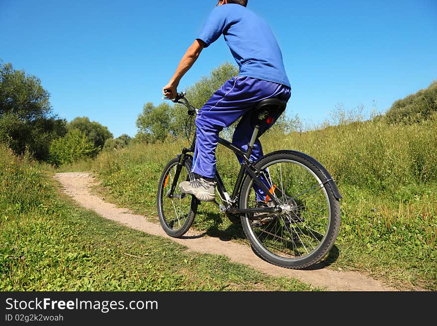 Back of man wearing sporty clothers. one man is riding on bicycle