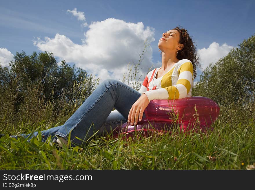 Young woman in summer day rest in the open air sitting on an inflatable armchair. Young woman in summer day rest in the open air sitting on an inflatable armchair