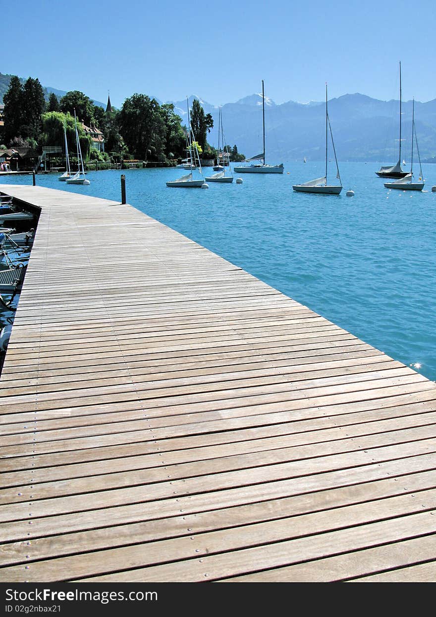 Wooden pier against lake Thun and Alps. Switzerland