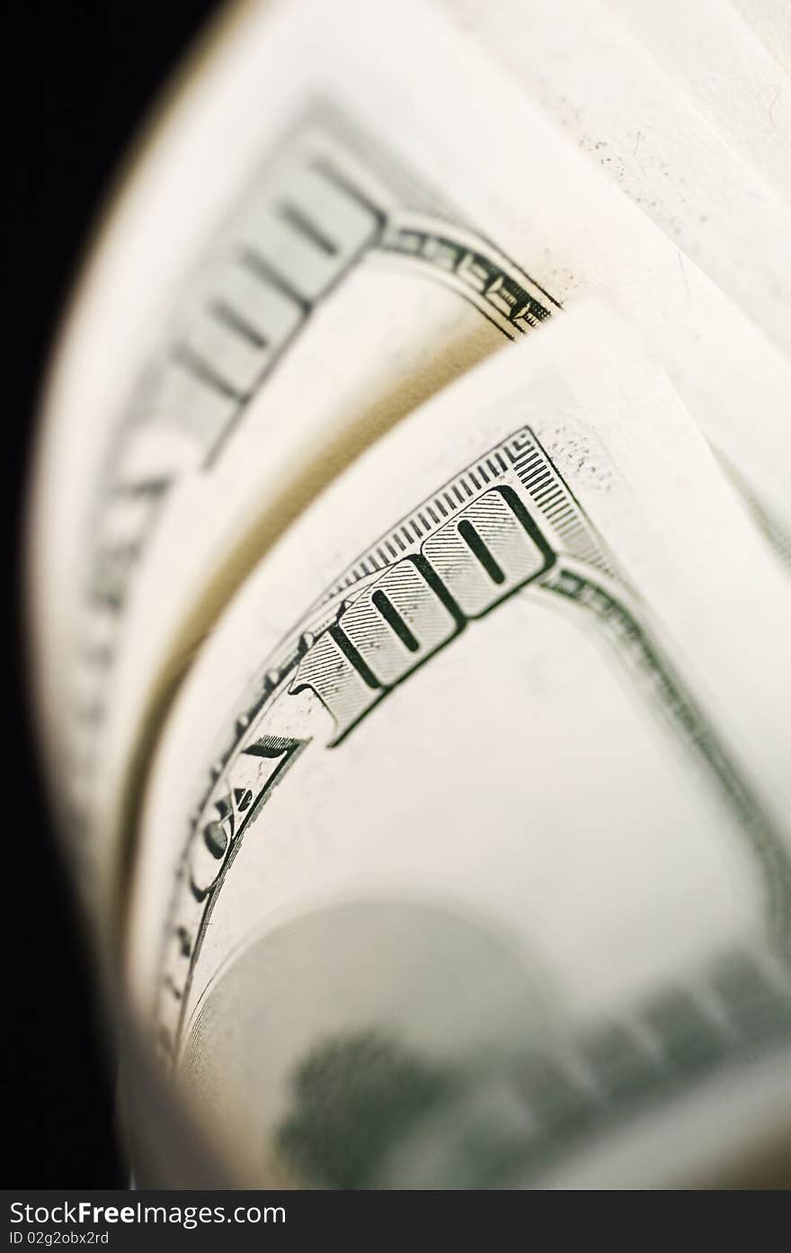 Close Up of Stack of dollars isolated on black background.