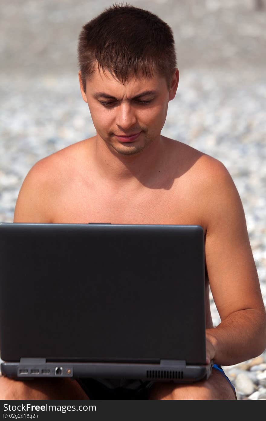 Young Guy Working On His Notebook On Seacoast