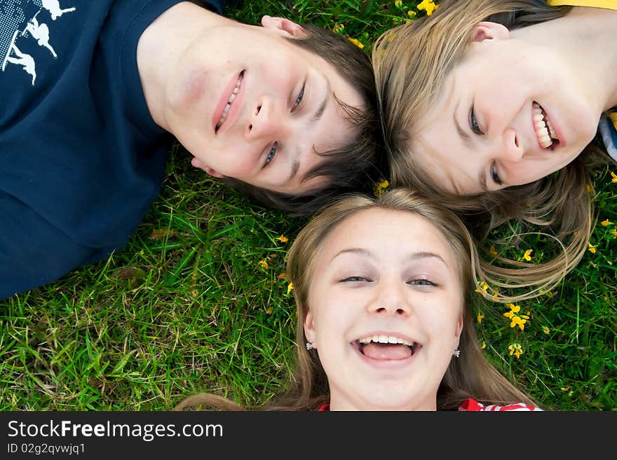 Three happy friends lay on a grass. Three happy friends lay on a grass