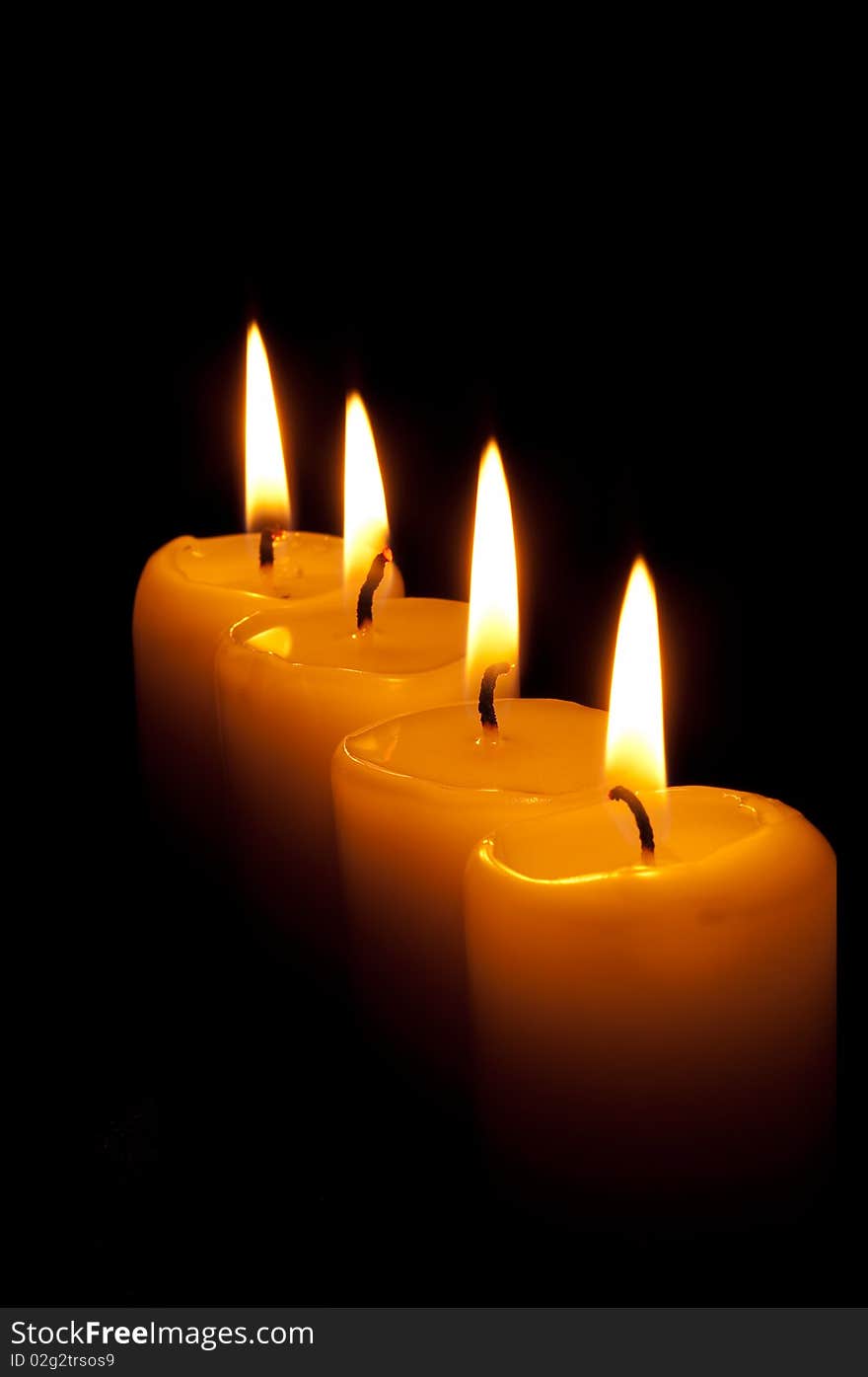 Group of four candles in the dark