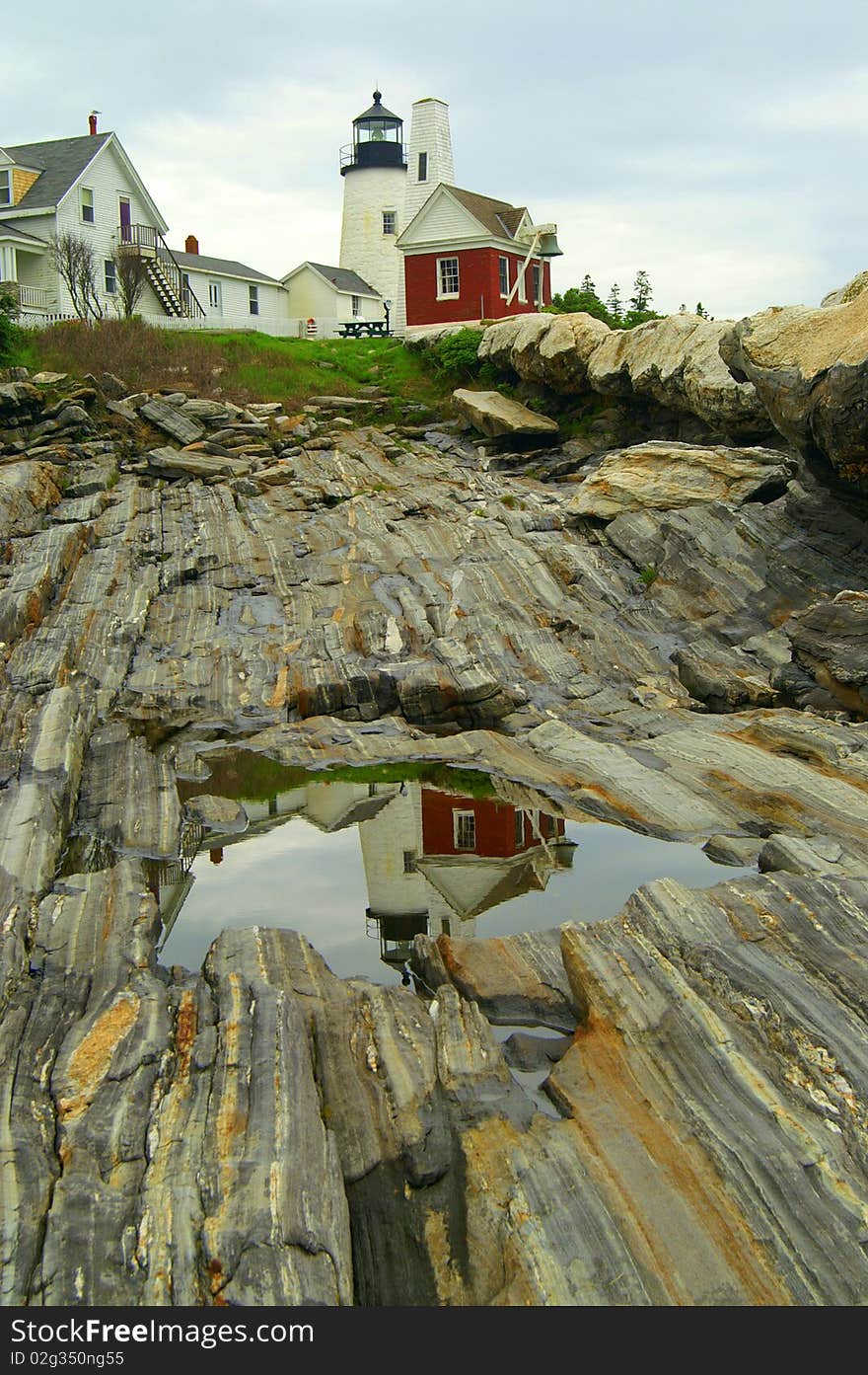 Pemaquid Point Lighthouse is located on the coast of Maine. A reflection of the lighthouse was seen in a pool of water on the granite rocks. Pemaquid Point Lighthouse is located on the coast of Maine. A reflection of the lighthouse was seen in a pool of water on the granite rocks.