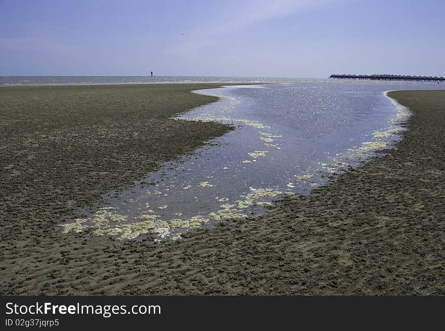 Tide water moving on textured sandy beach. Tide water moving on textured sandy beach