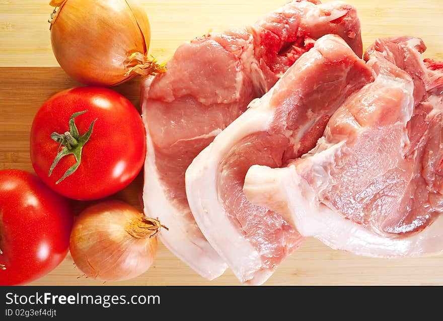 Meat and vegetables on an wooden cutting board