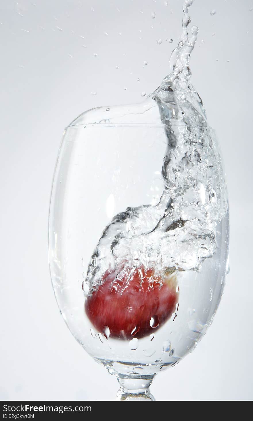 Macro shot of isolated splash of water in a cup on white background. Macro shot of isolated splash of water in a cup on white background