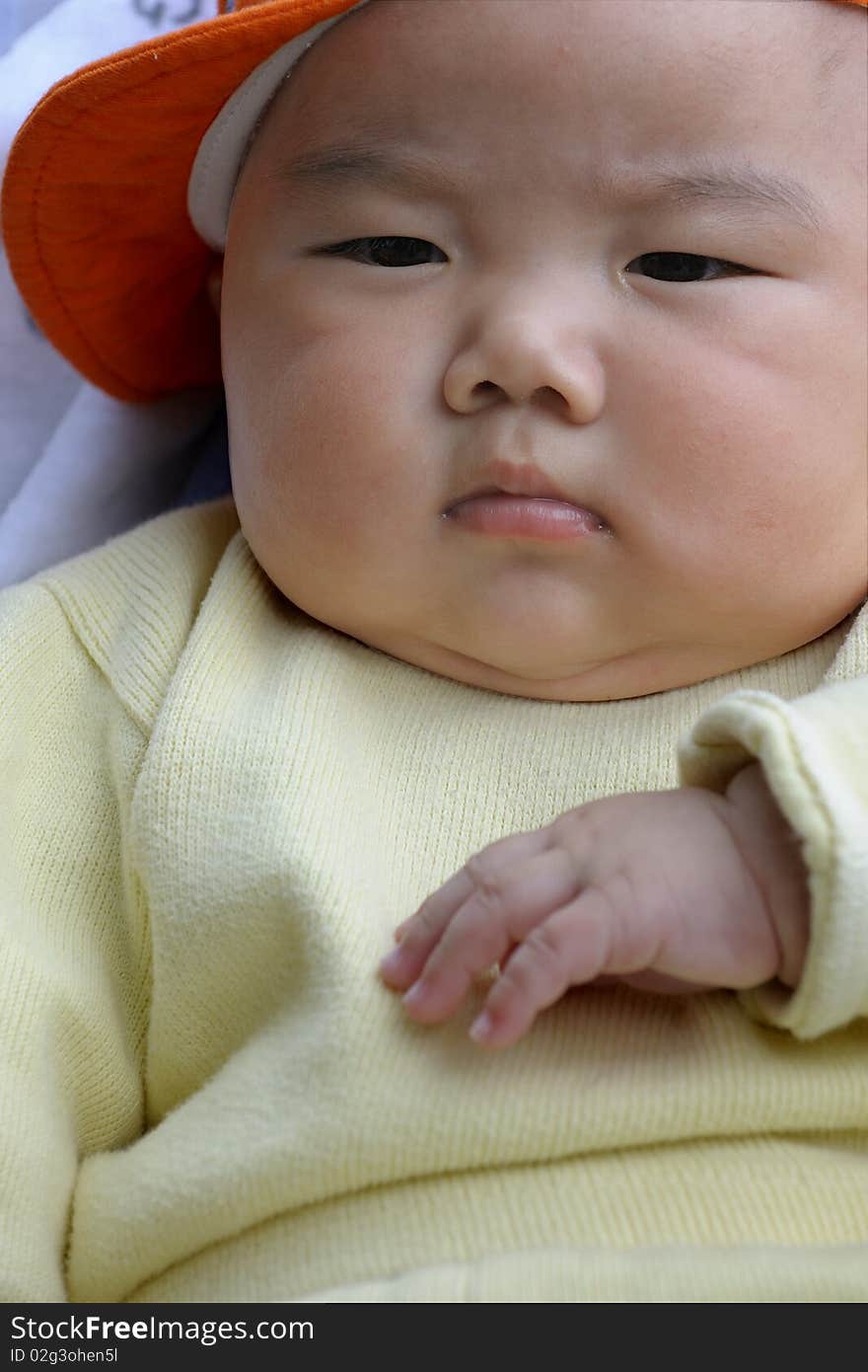 A cute baby with a orange cap.