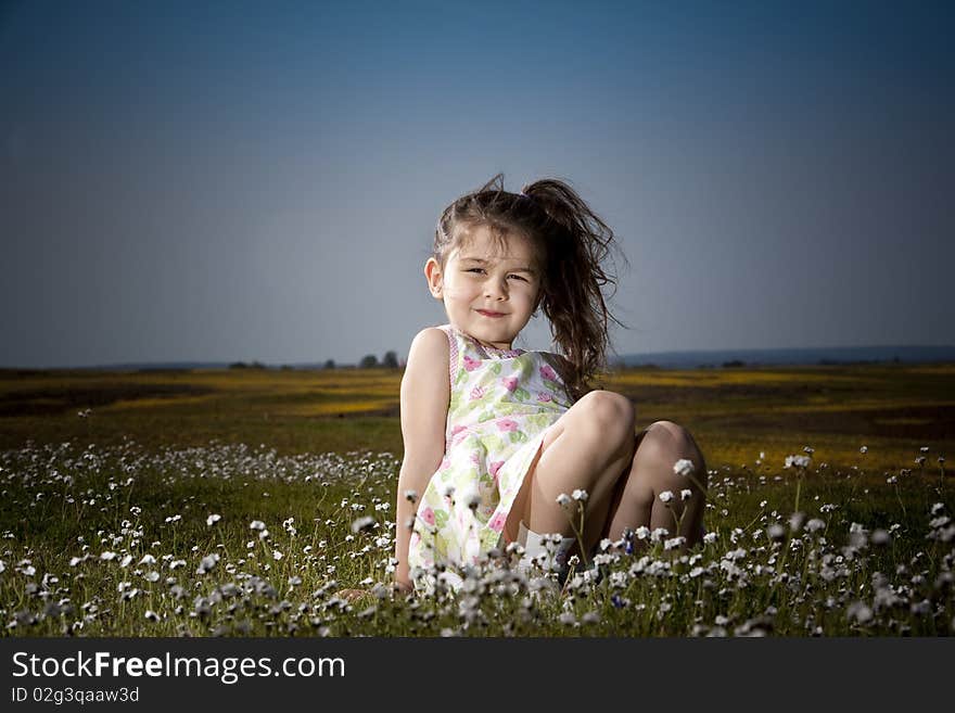 Little girl sitting in a field of white flowers. Little girl sitting in a field of white flowers