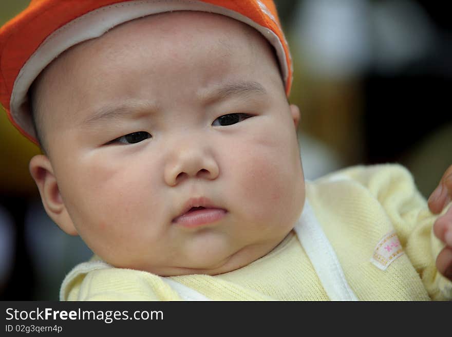 A cute baby with a orange cap.