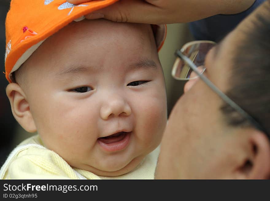 A cute baby with a orange cap.