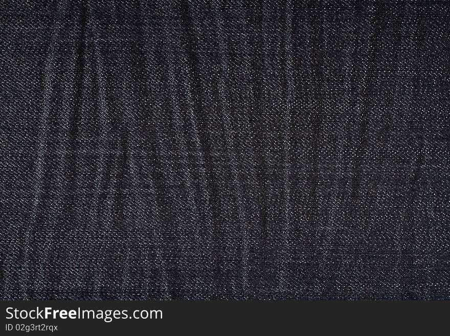 Wrinkled black jeans close up