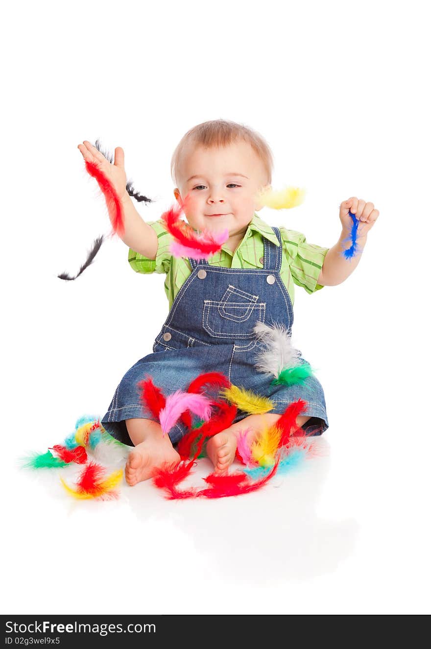 Little boy is sitting on a flow with feathers