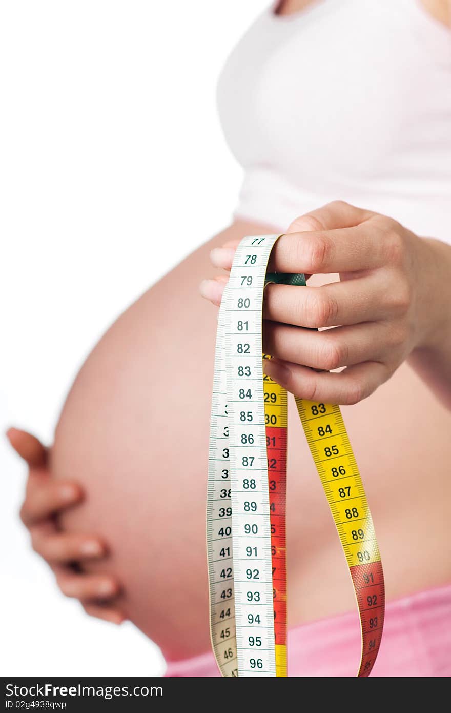 Pregnant girl with measuring tape in the hand